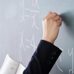 A snapshot of a hand writing math formula on a blackboard